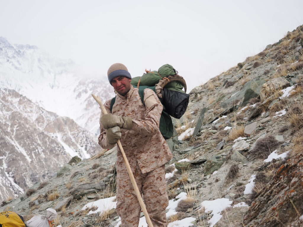 Dovlatyor taking a turn carrying the ibex off the mountain